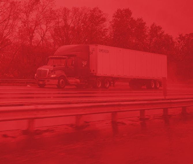 Semi truck driving down the highway with a red overlay