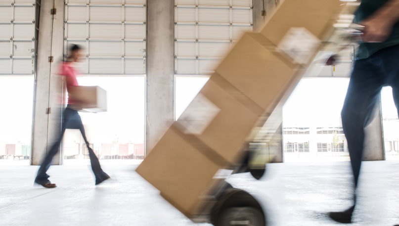 people carrying packages in warehouse